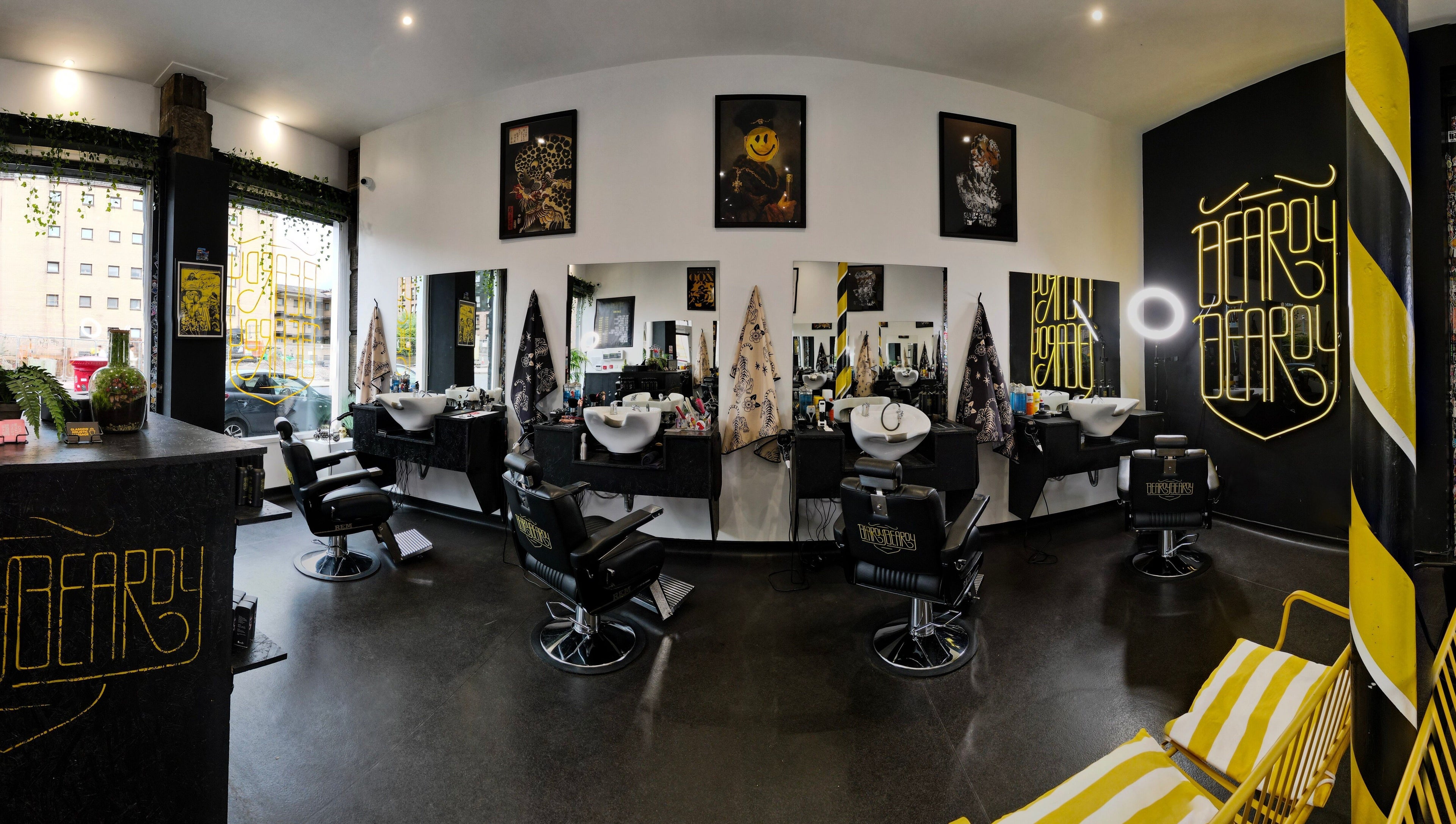 Interior view of BeardyBeardyFinnieston salon in Glasgow, Scotland, GB featuring chic chairs and neon signage.