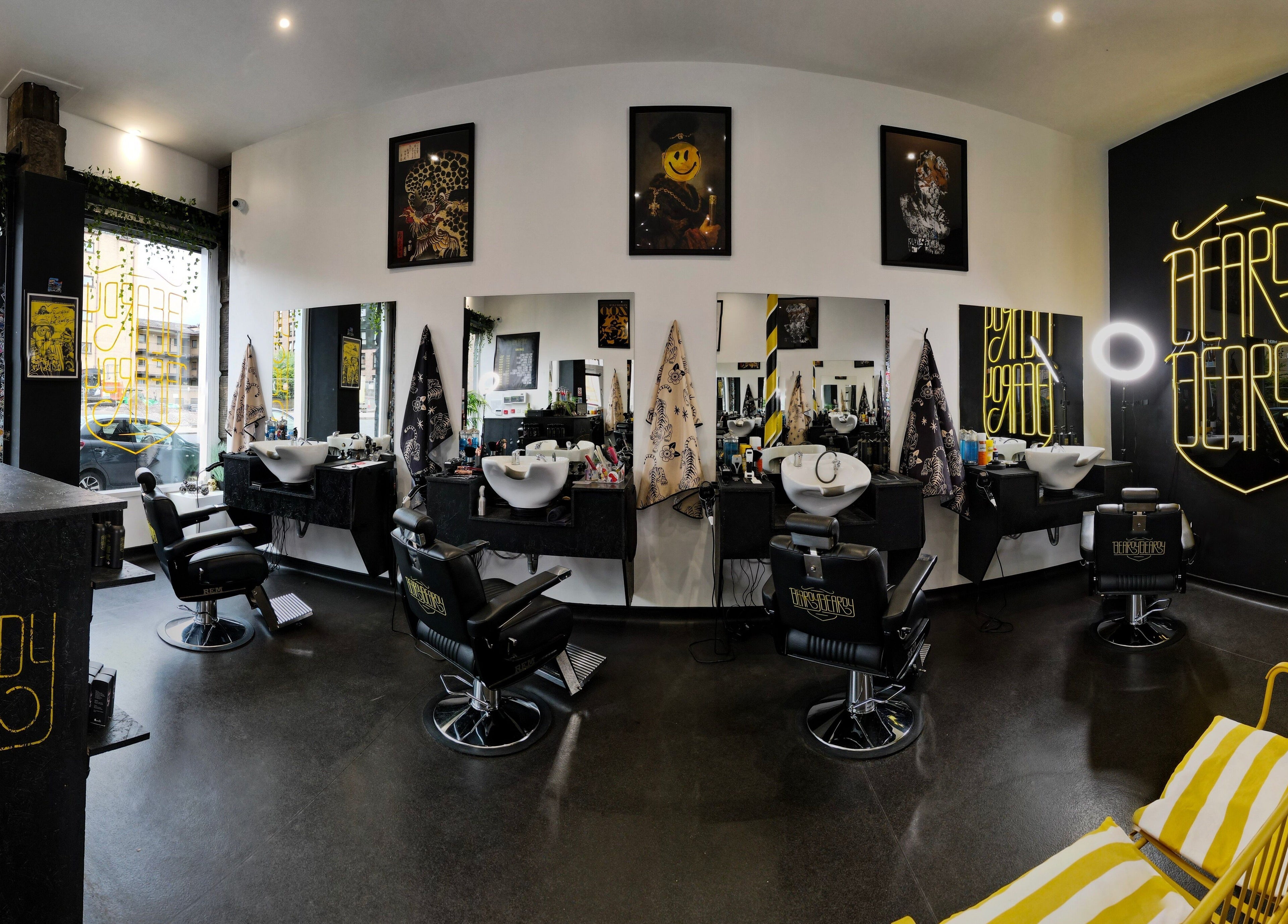 Interior view of BeardyBeardyFinnieston salon in Glasgow, Scotland, GB featuring chic chairs and neon signage.