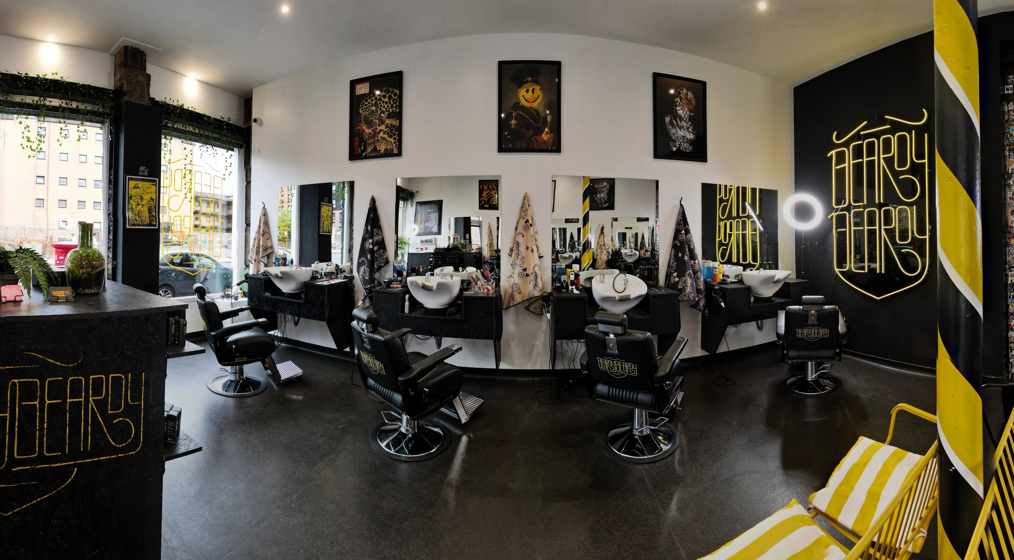 Interior view of BeardyBeardyFinnieston salon in Glasgow, Scotland, GB featuring chic chairs and neon signage.