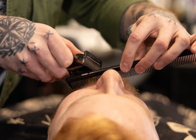Expert beard trimming at BeardyBeardyFinnieston, Glasgow, Scotland, GB with precise clipper and comb technique.