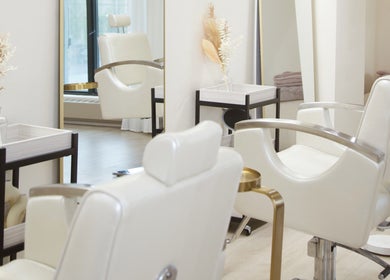 Elegant white salon chairs at JL Beauty World, Toronto, Ontario, CA, with refined decor for a luxurious experience.