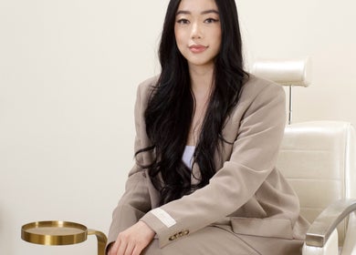 Professional woman seated at JL Beauty World, Toronto, Ontario, CA, showcasing modern style and elegance.
