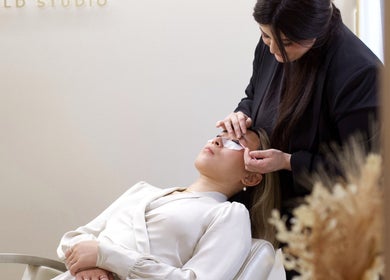 Eyelash treatment at JL Beauty World, Toronto, Ontario, CA. Beautician applies patches during lash session.