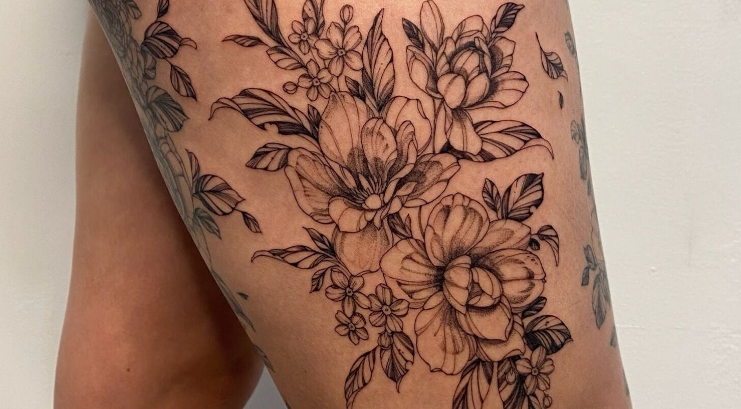 Floral thigh tattoo art at Kelly Ye Tattoos @iisye in Toronto, Ontario, CA. Exquisite line work and design.