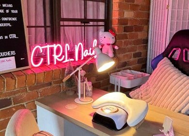 Cozy nail station at Ctrl Nails in Tinana, Queensland, AU, with neon sign and comfy chair.