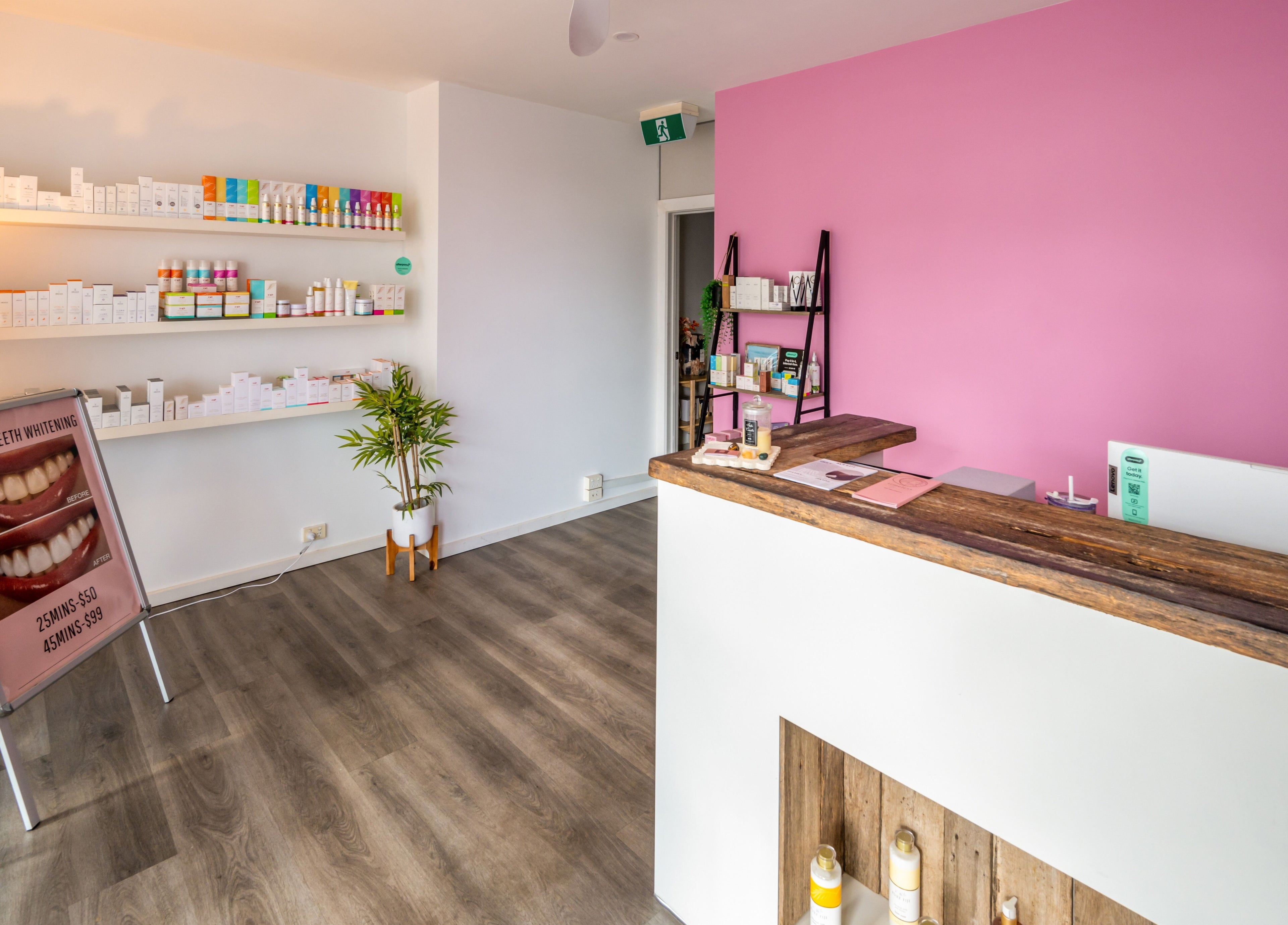 Reception area at Timeless Day Spa in Rye, VIC, AU with pink wall and product display.
