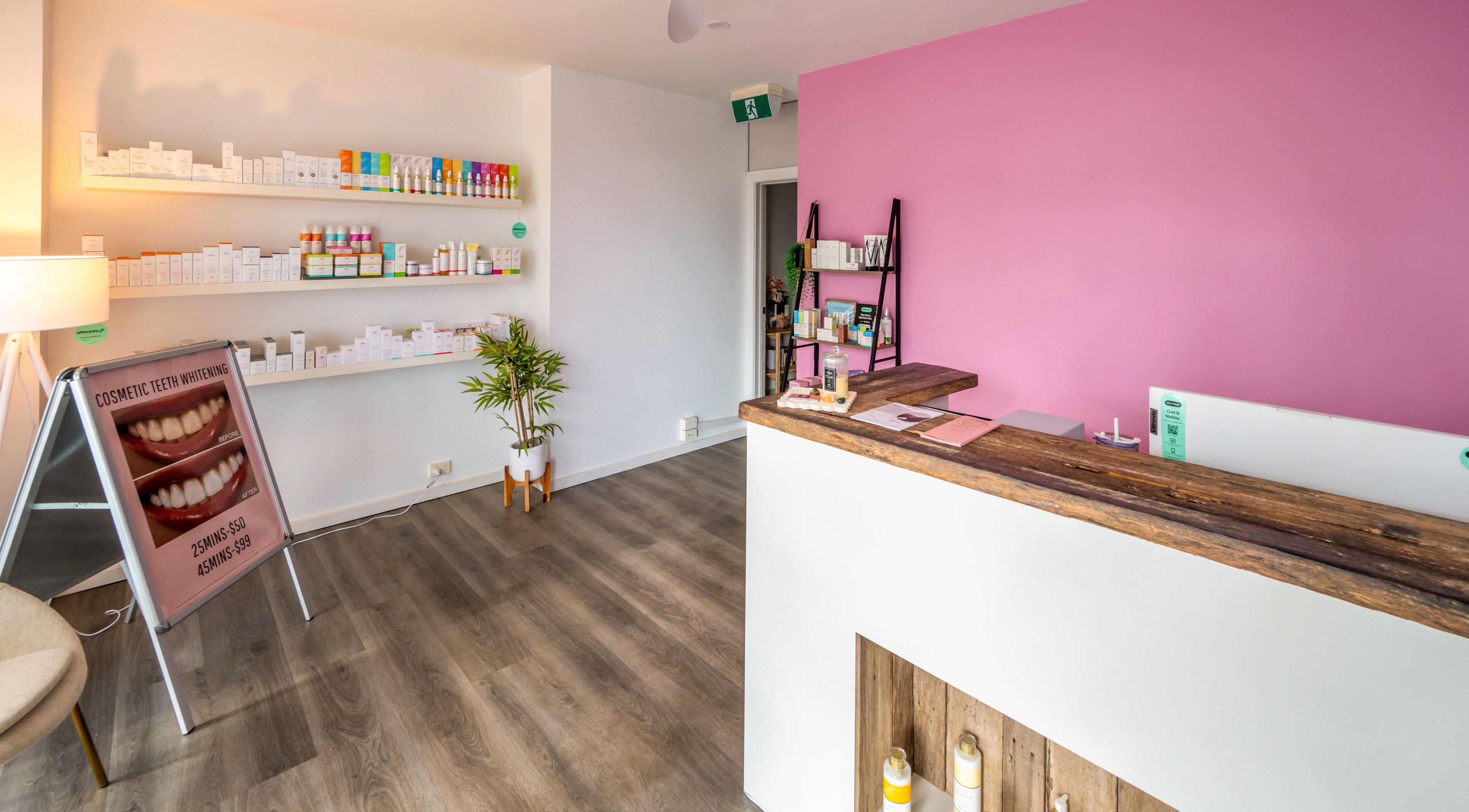 Reception area at Timeless Day Spa in Rye, VIC, AU with pink wall and product display.