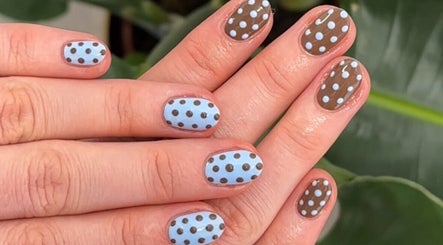 Stylish polka dot nail art at Aura Nail Art Studio, Altrincham, England, GB. Brown and blue design.