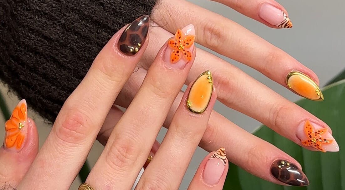 Stylish nail art at Aura Nail Art Studio in Altrincham, England, GB, showcasing vibrant orange and brown designs.