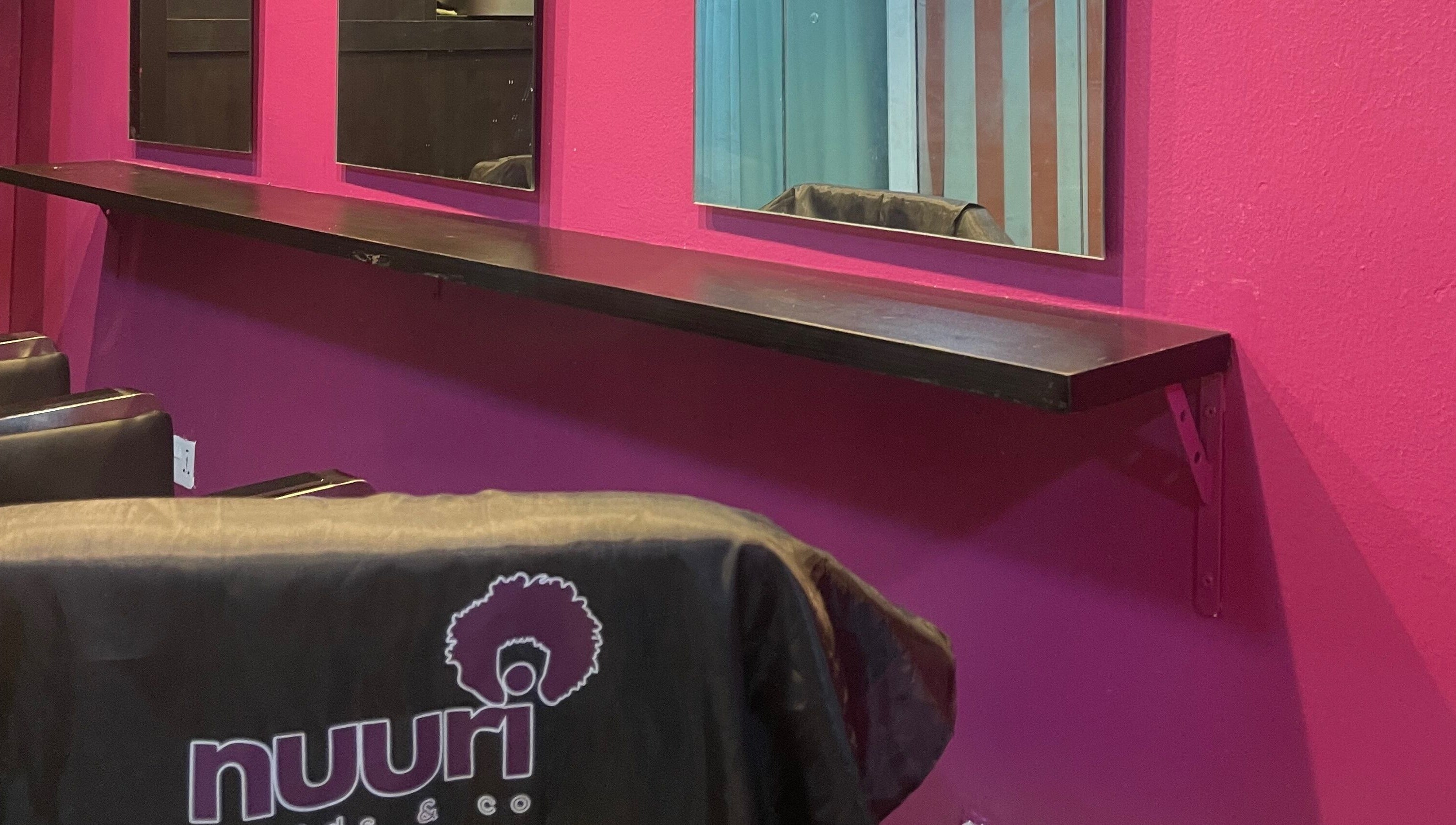 Chic interior of Nuuri Braids n Co in Lagos, NG, featuring mirrors and vibrant decor.