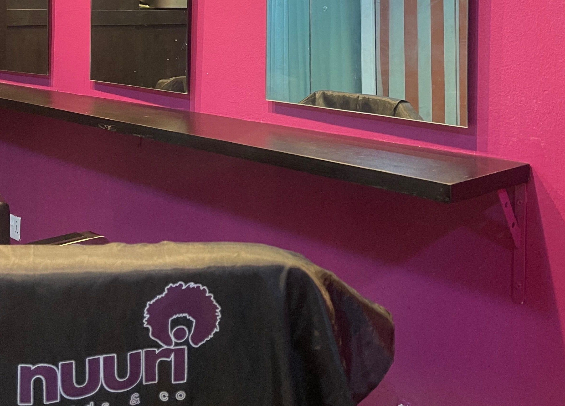 Chic interior of Nuuri Braids n Co in Lagos, NG, featuring mirrors and vibrant decor.