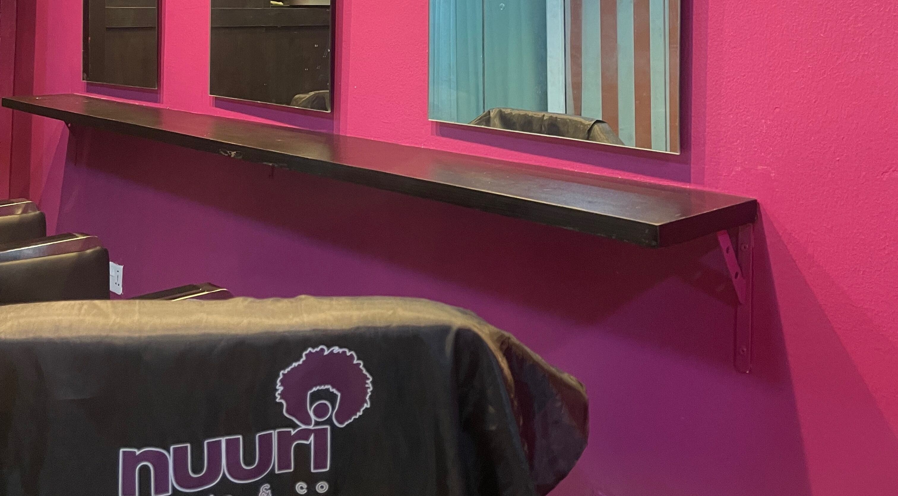 Chic interior of Nuuri Braids n Co in Lagos, NG, featuring mirrors and vibrant decor.