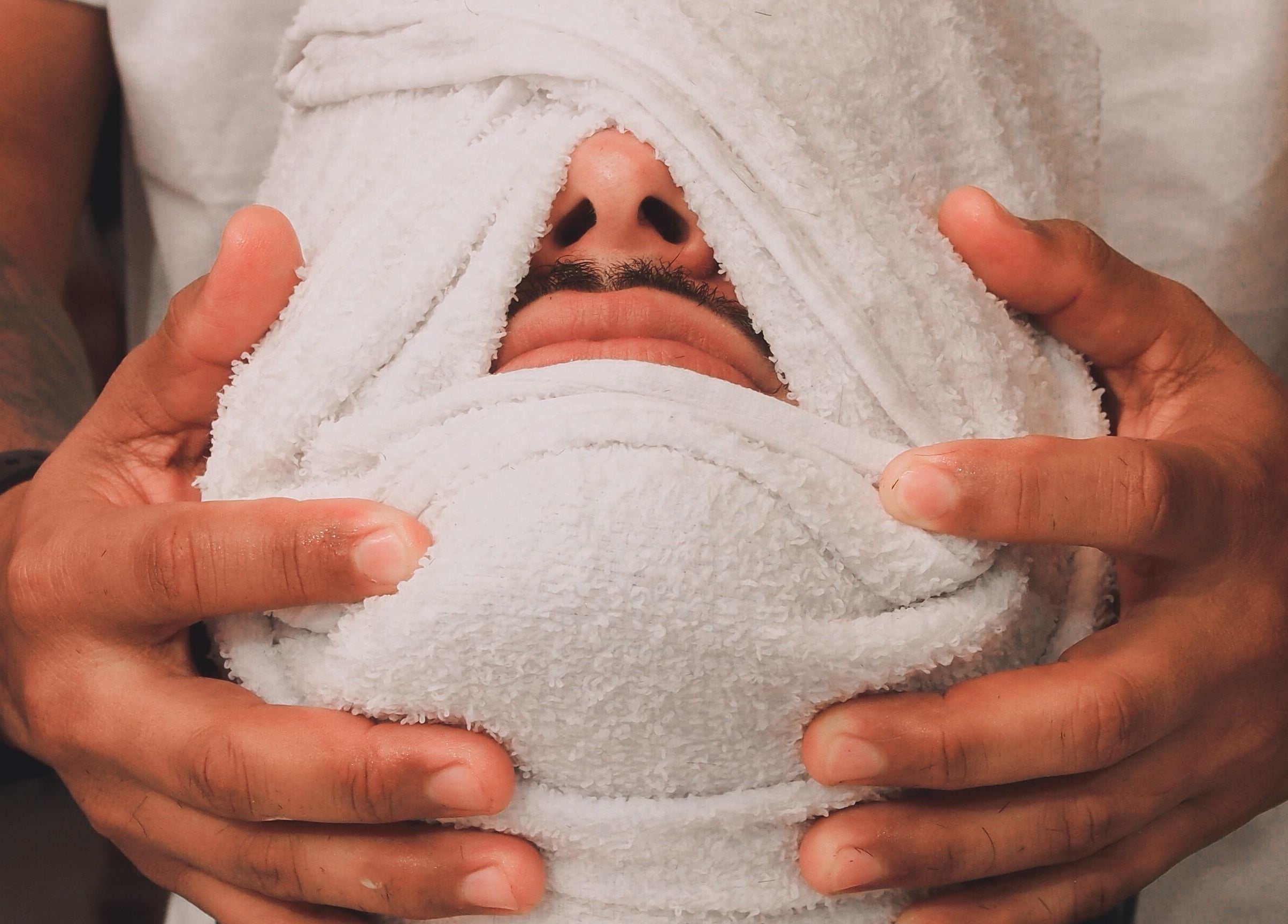 Tratamento facial com toalha em Martini Barbearia, Pará, Pará, BR, para relaxamento e bem-estar masculino.