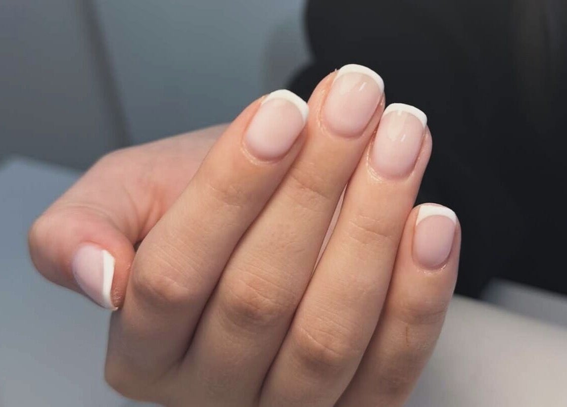 A fresh French manicure at GET GLAM studio in Blaenavon, Wales, GB, showcasing neat and polished nails.