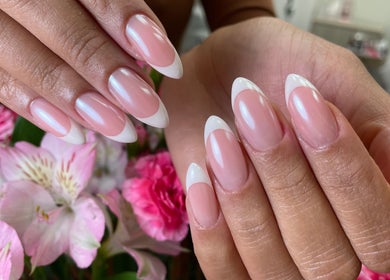 French manicure at Chic Nail Studio, Arlington, Virginia, US with delicate floral backdrop.