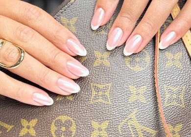 Close-up of a chic French manicure at Chic Nail Studio, Arlington, Virginia, US, holding a designer purse.