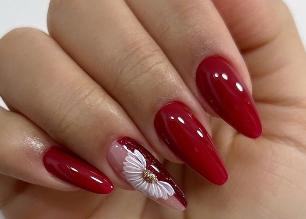 Elegante diseño de uñas rojas con flor en Nails & Lashes Studio By Roxana Suares, Willemstad, Curaçao, CW.