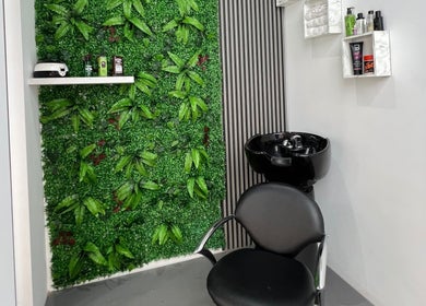 Κομψός χώρος με πράσινο τοίχο στο Van Barber Shop, Κουφάλια, GR με μοντέρνα καρέκλα και νιπτήρα.