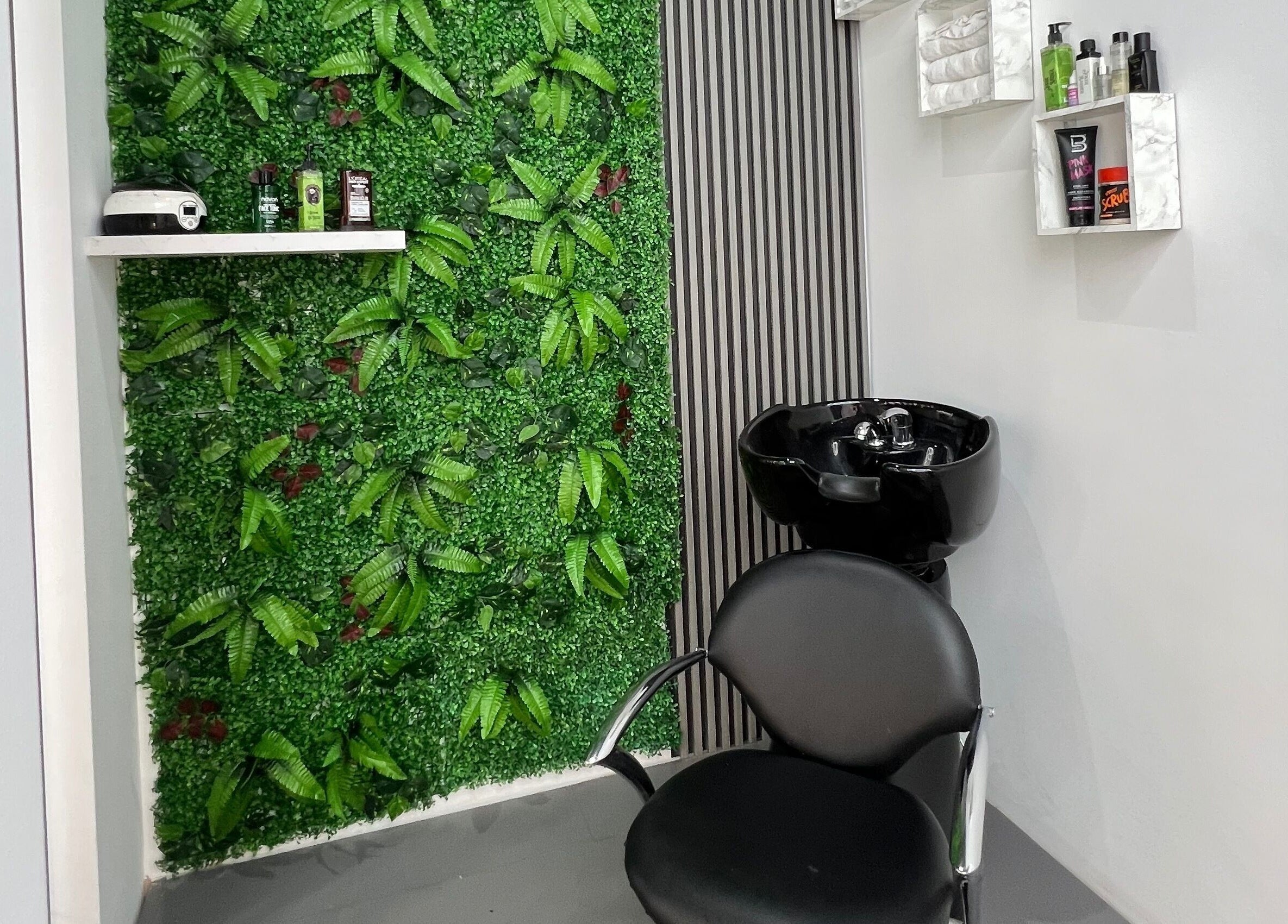 Κομψός χώρος με πράσινο τοίχο στο Van Barber Shop, Κουφάλια, GR με μοντέρνα καρέκλα και νιπτήρα.