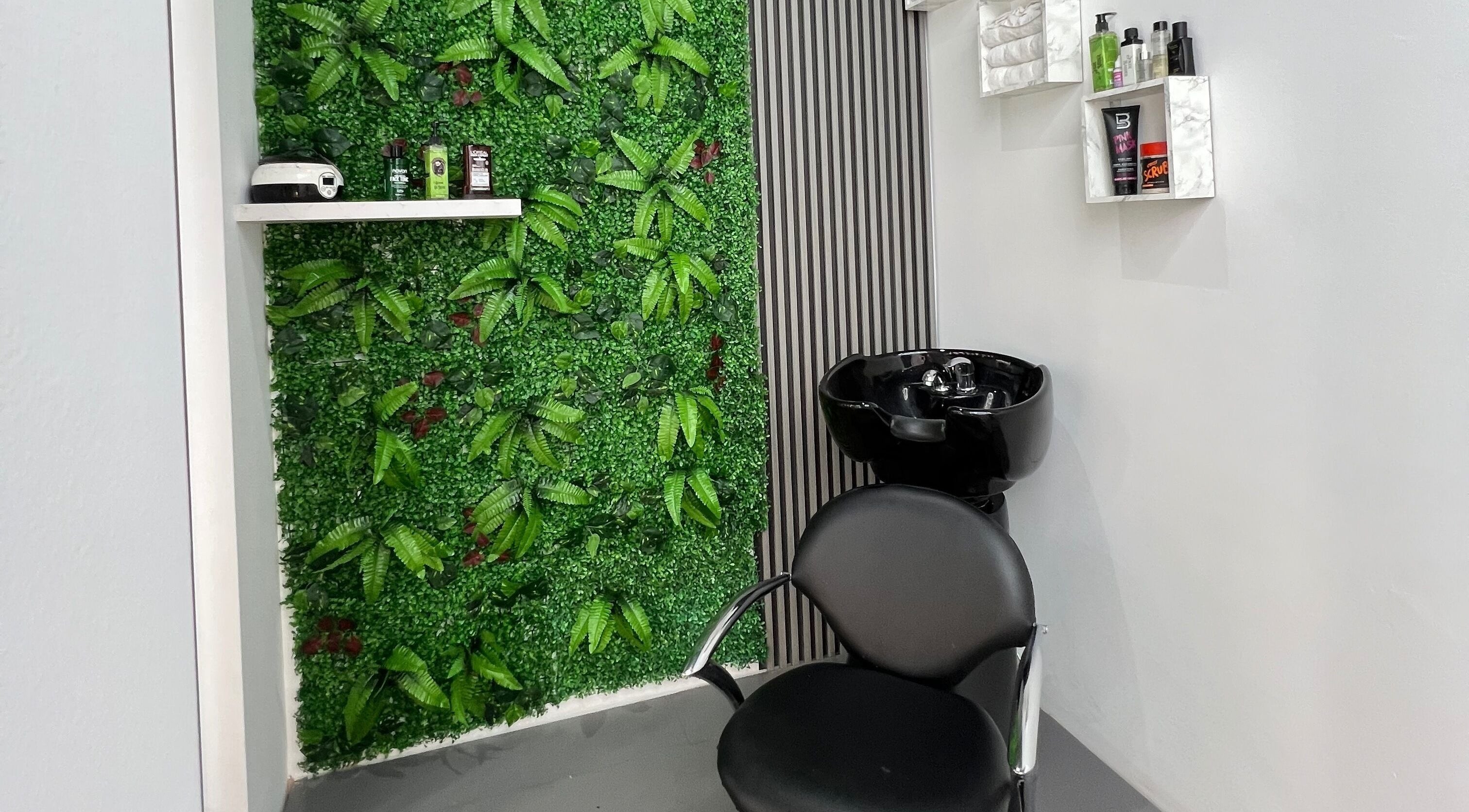 Κομψός χώρος με πράσινο τοίχο στο Van Barber Shop, Κουφάλια, GR με μοντέρνα καρέκλα και νιπτήρα.