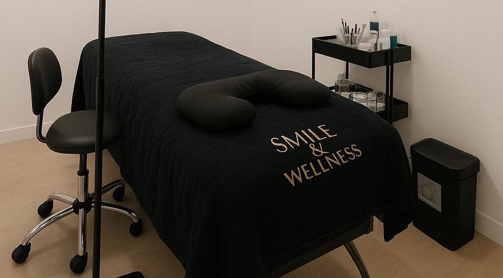 Sala de terapia en Smile Wellness, Barcelona, Catalunya, ES, con camilla negra y silla ergonómica.