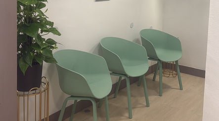 Sillas verdes en Smile Wellness, Barcelona, Catalunya, ES, creando un ambiente acogedor.