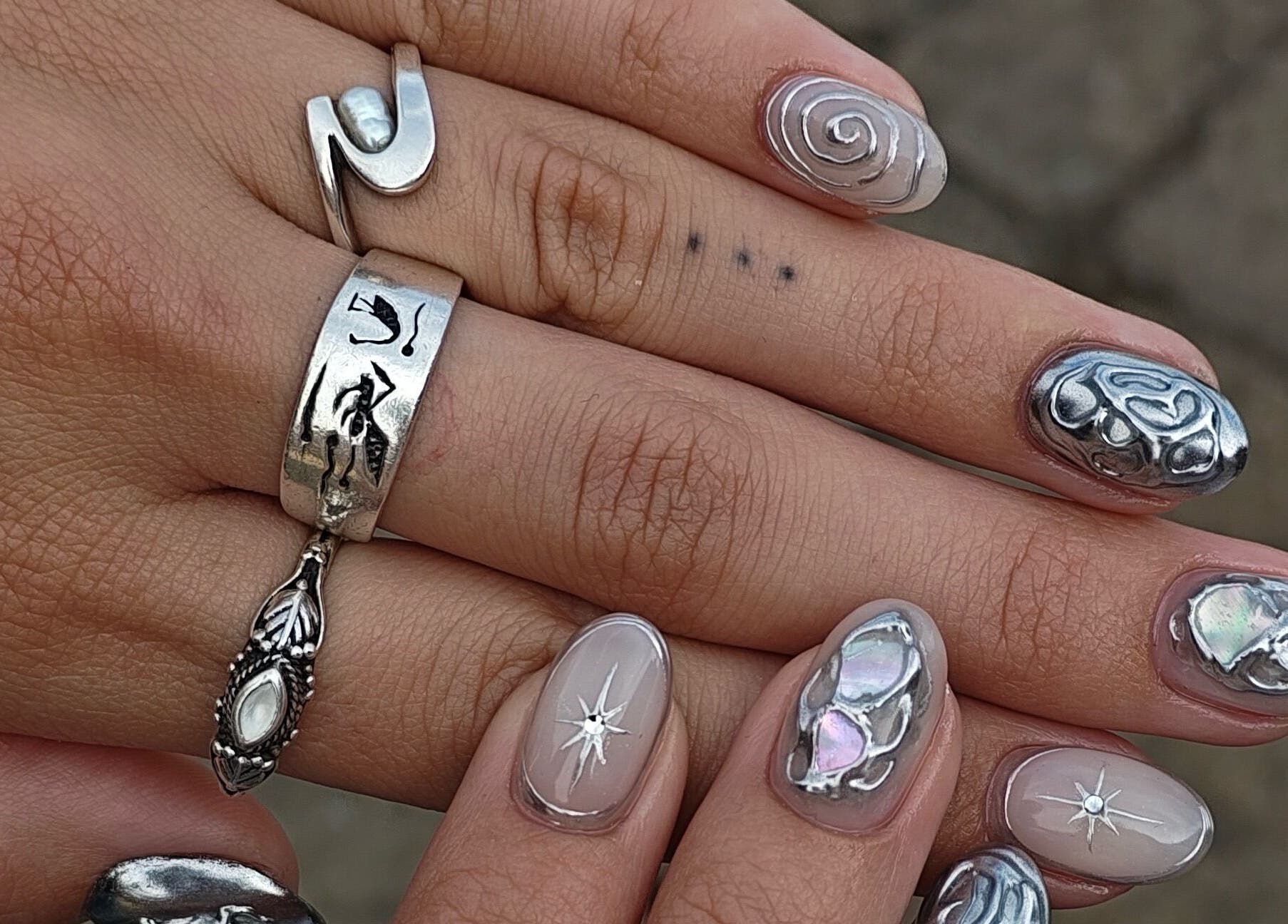 Intricate nail art with metallic designs at Sofia's Studio 444 in Montréal, Québec, CA.