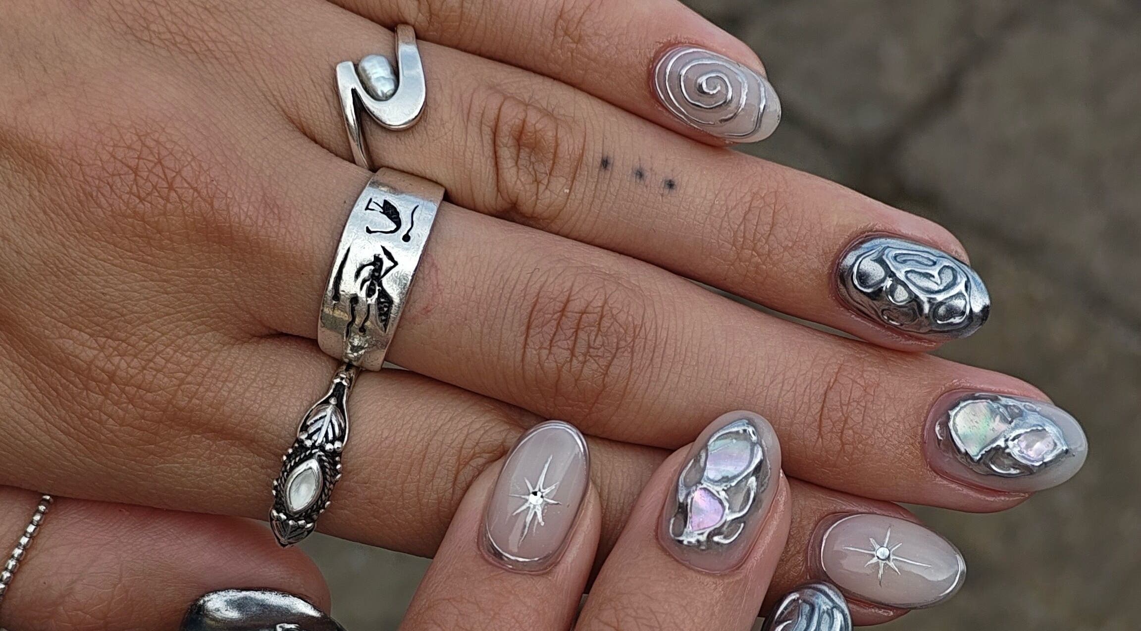 Intricate nail art with metallic designs at Sofia's Studio 444 in Montréal, Québec, CA.