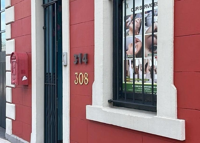 Charming facade of Mystic Spa & Wellness in Petersham, New South Wales, AU with a red wall and window display.