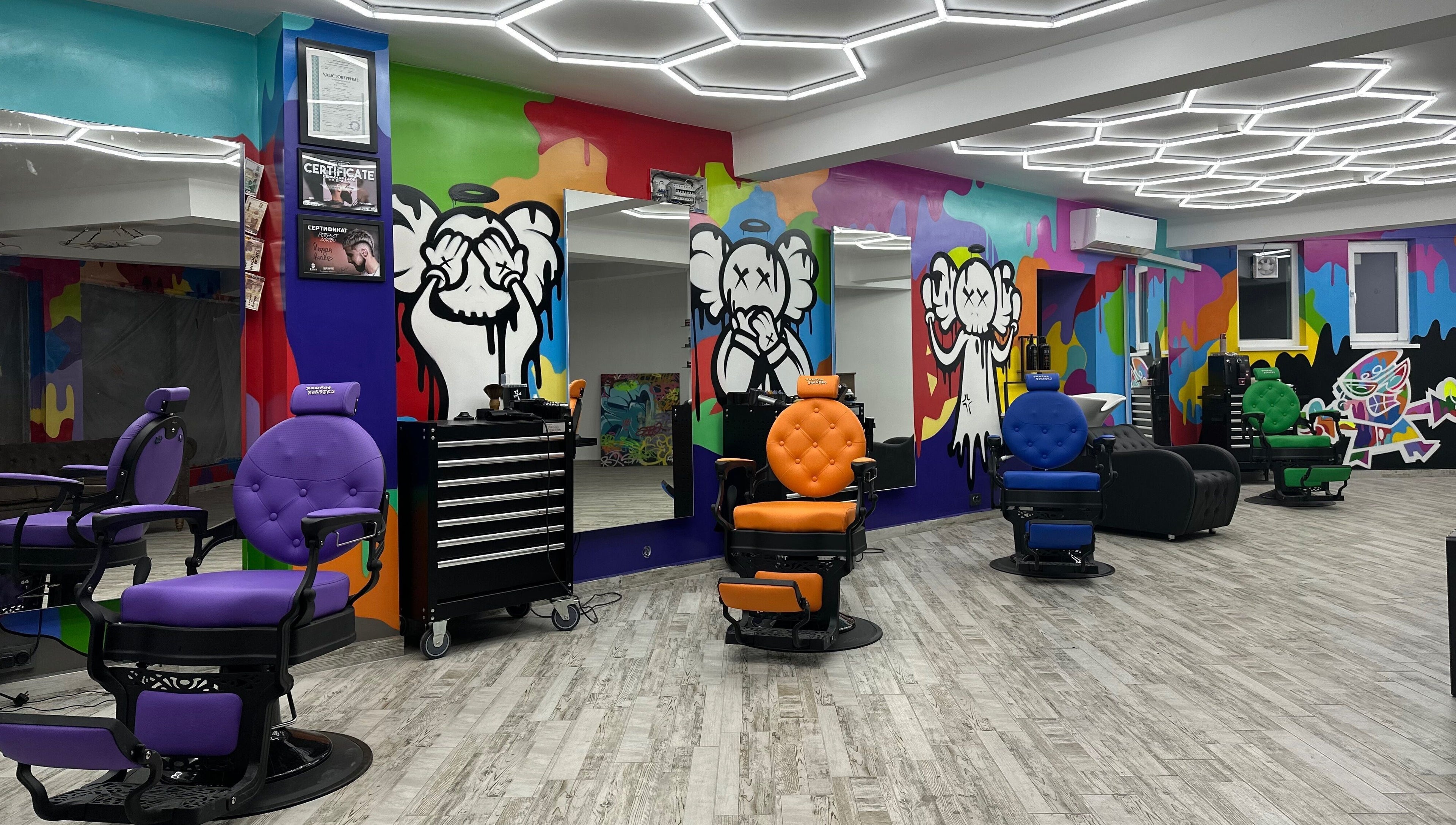 Интериор на Brutal Barbers Barbershop във Варна, Варна, BG с цветни столове и графити стени.