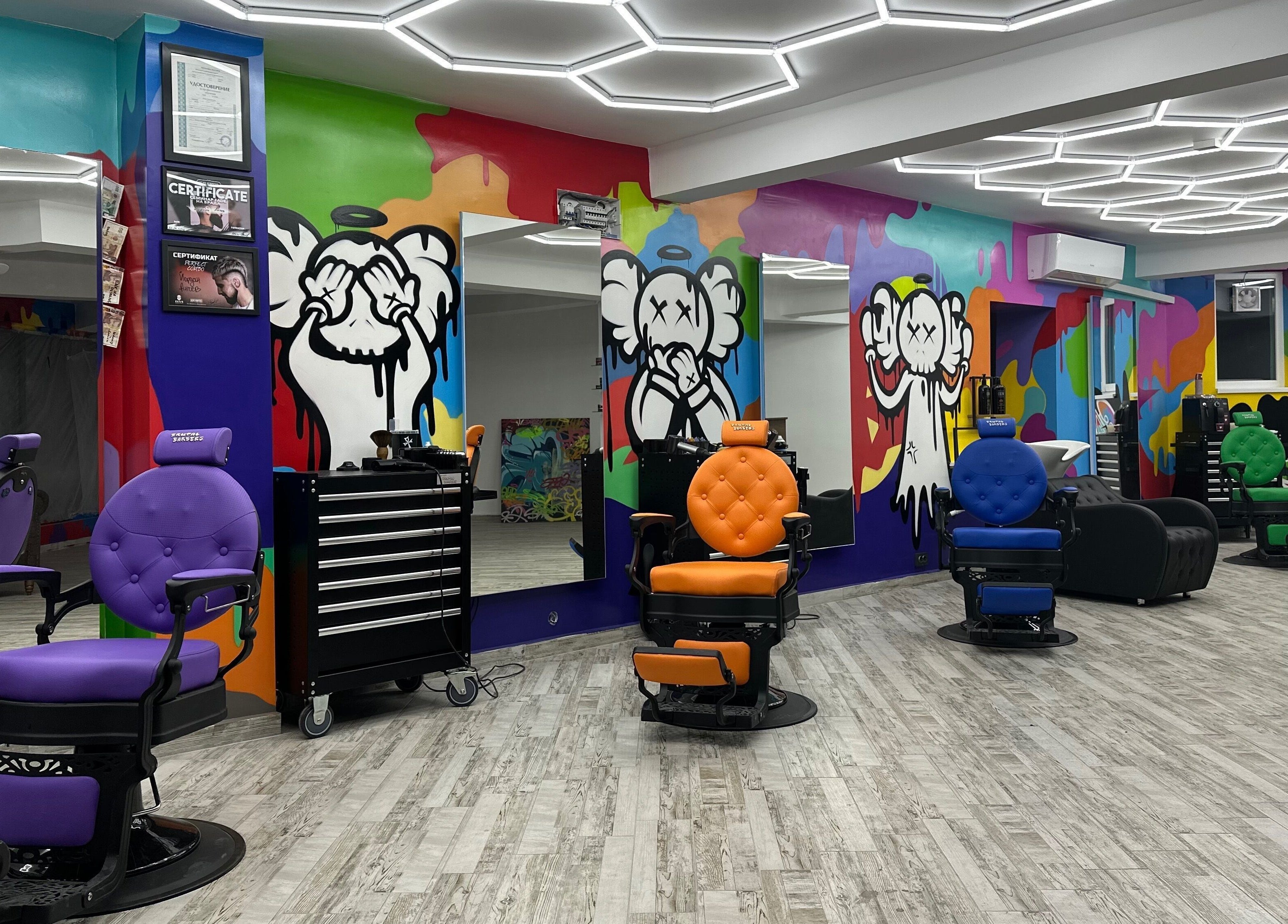 Интериор на Brutal Barbers Barbershop във Варна, Варна, BG с цветни столове и графити стени.