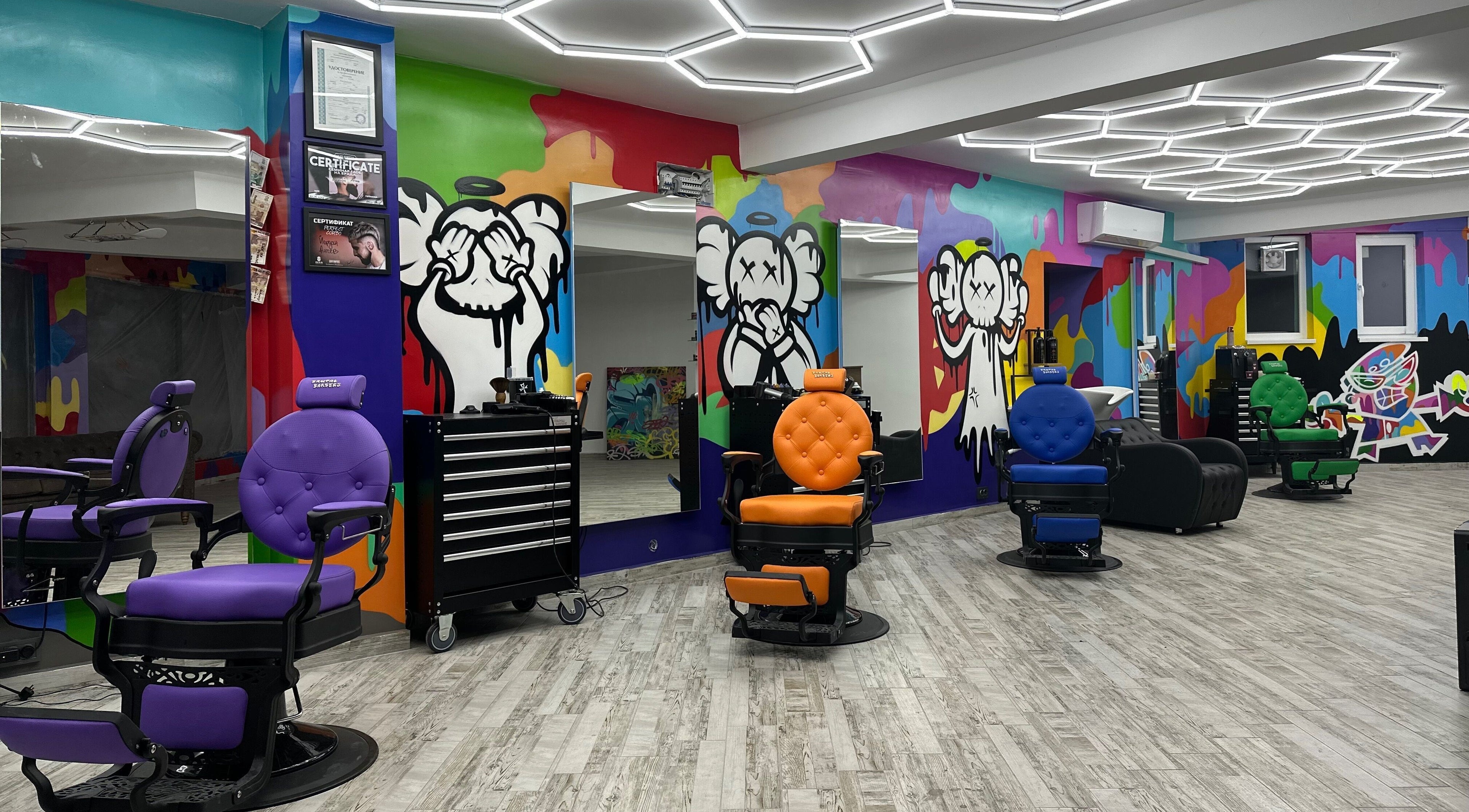 Интериор на Brutal Barbers Barbershop във Варна, Варна, BG с цветни столове и графити стени.