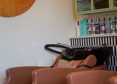 Warm-toned salon with shampoo area at In Salon, Yellow Springs, Ohio, US, featuring chic decor.