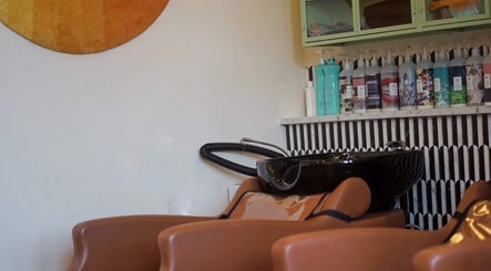 Warm-toned salon with shampoo area at In Salon, Yellow Springs, Ohio, US, featuring chic decor.