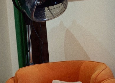 Vibrant salon chair with vintage dryer at In Salon, Yellow Springs, Ohio, US, offering chic styling.