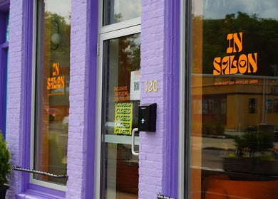 Purple exterior of In Salon in Yellow Springs, Ohio, US featuring bright orange signage.