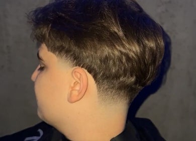 Moderne Herrenfrisur bei Razorhood in Bern, Bern, CH, mit stilvoll geschnittenem Haar und scharfer Fade-Technik.