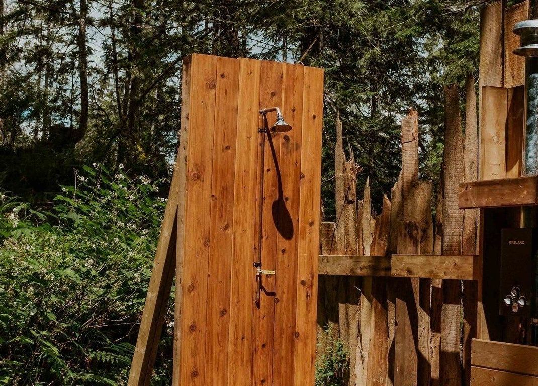 Outdoor shower at The Moonshine Spa in Madeira Park, British Columbia, CA, surrounded by lush forest greenery.