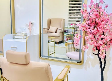 Elegant De Bliss Beauty Lounge interior in Dubai, دبي, AE, featuring plush chairs and cherry blossom decor.