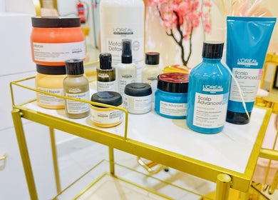Premium hair care products at De Bliss Beauty Lounge in Dubai, دبي, AE displayed on a gold salon cart.
