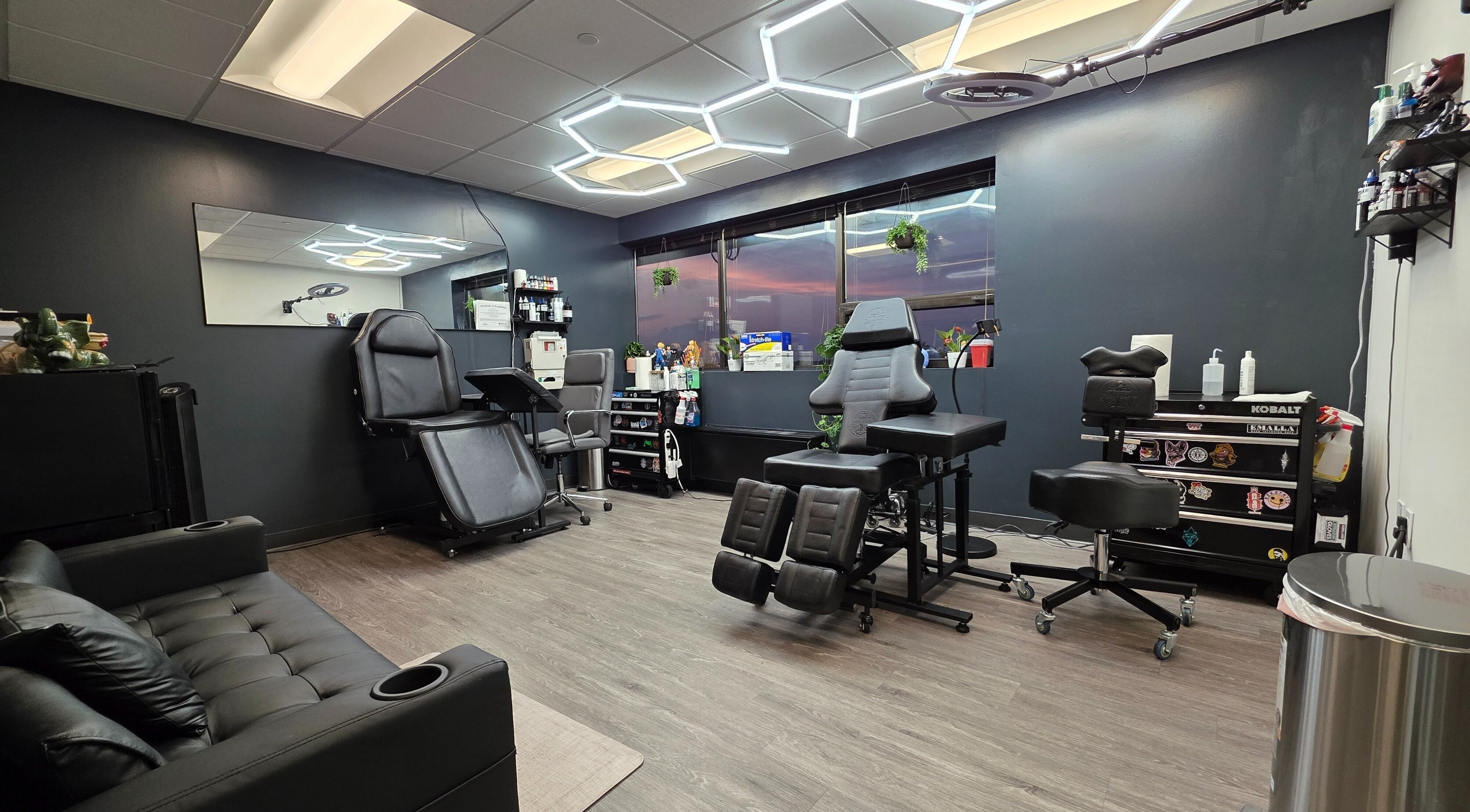 Interior moderno de David Tattoo en Fairfax, Virginia, US, con cómodas sillas para tatuajes y decoración elegante.