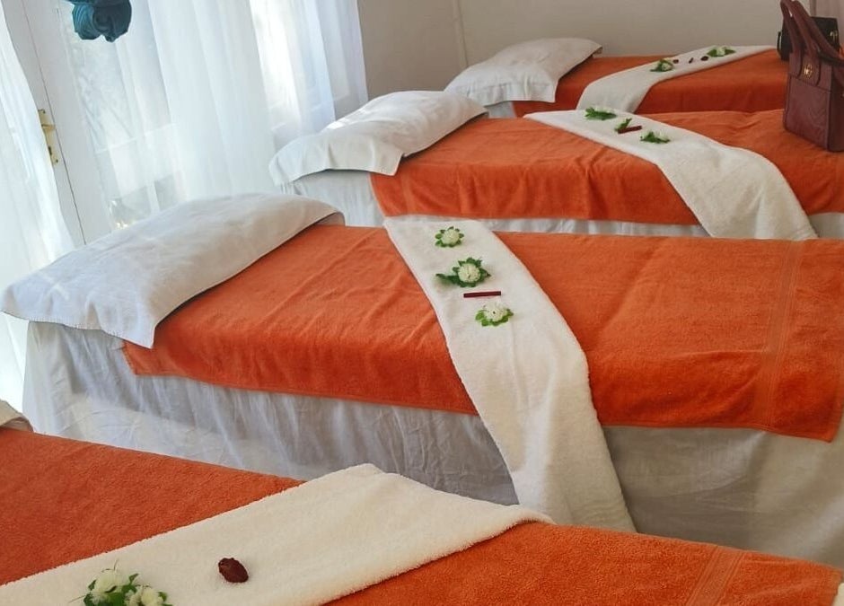 Massage tables with orange linens at La Vita E Bella Spa, Johannesburg, Gauteng, ZA, exuding relaxation.