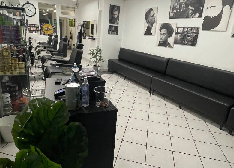 Intérieur moderne de Sculpt Barber Shop, Clermont-Ferrand, avec fauteuils et affiches murales élégantes.