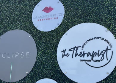 Eclipse Aesthetic Centre signage in Bloemfontein, Free State, ZA displayed on a lush green backdrop.