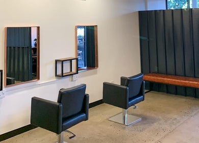 Elegant salon setup at The Hair Company, Umhlanga, Kwazulu-natal, ZA, featuring modern black chairs.