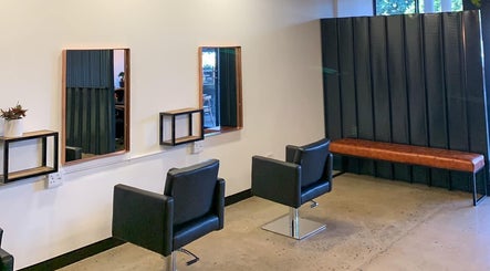 Elegant salon setup at The Hair Company, Umhlanga, Kwazulu-natal, ZA, featuring modern black chairs.