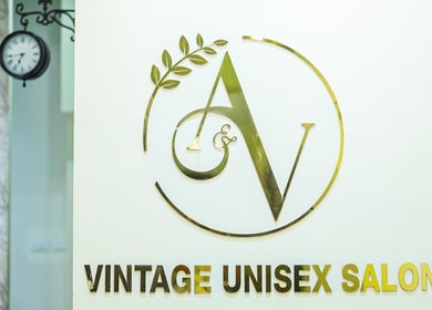 Vintage Unisex Salon logo with gold lettering and leaf design in Kochi, Kerala, IN.