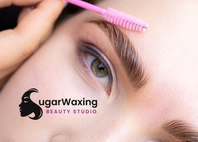 Eyebrow grooming at SugaZap Studio in Auckland, NZ with a pink brush showing precise beauty care.