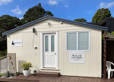 Exterior of Sugar Waxing & Beauty Studio in Auckland, NZ, featuring a cozy entrance and lush surroundings.