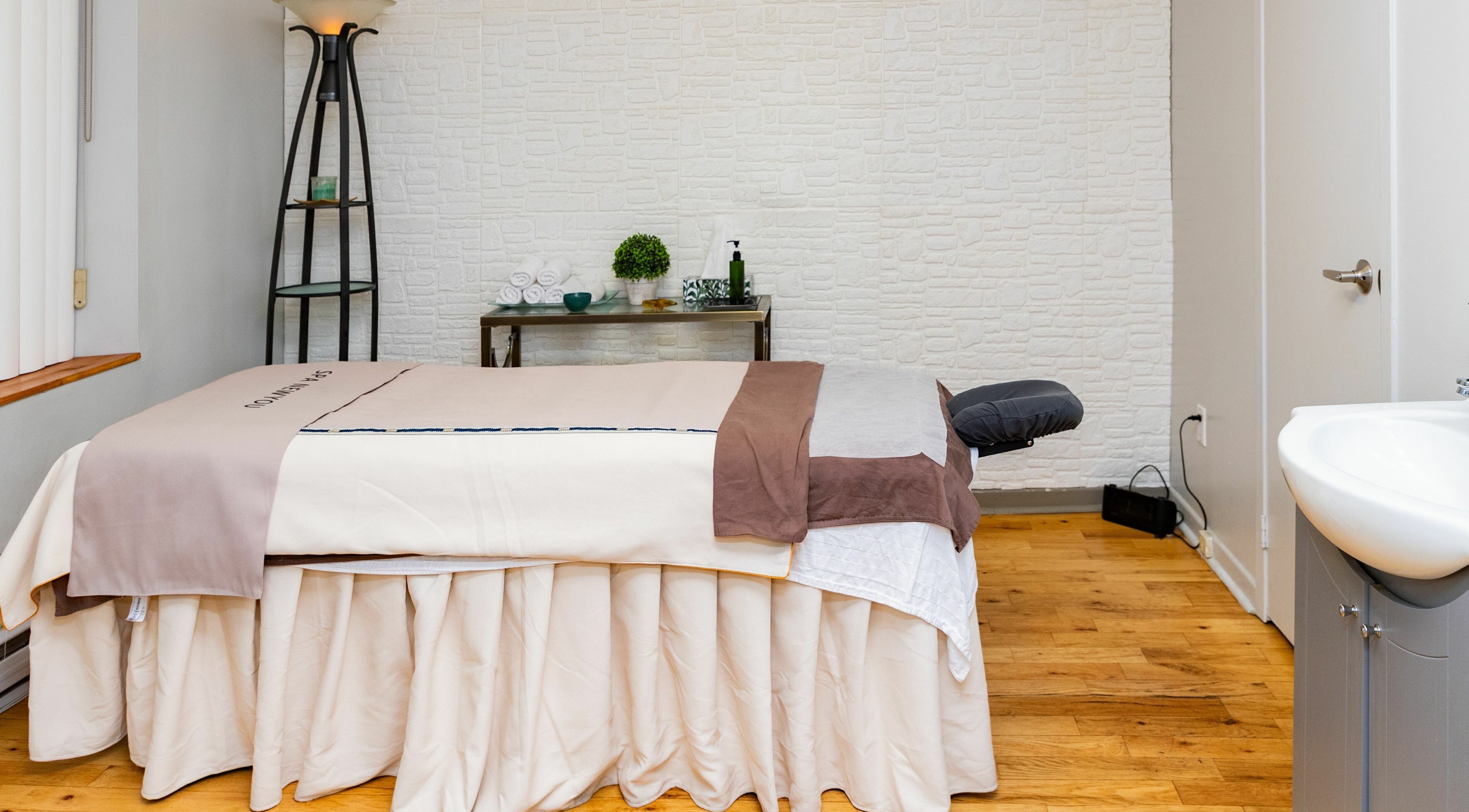 Spa NewYU massage room with a cozy bed in Montréal, Québec, CA, offering a serene relaxation space.